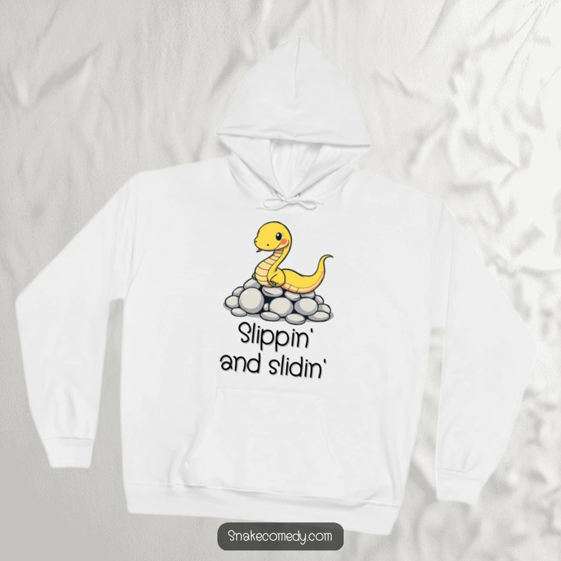 Funny snake hoodie showing a cartoon snake comically slipping on smooth round stones, offering warm, humorous comfort.