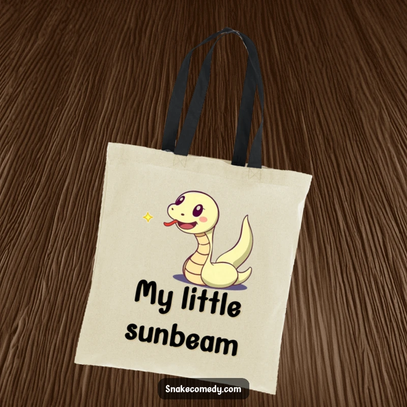 Funny tote bag showing a snake character with its tongue out, excitedly pursuing a small, dancing speck of light.